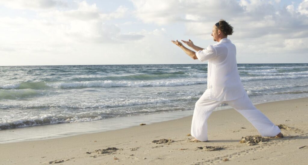 Man on beach practicing Qigong